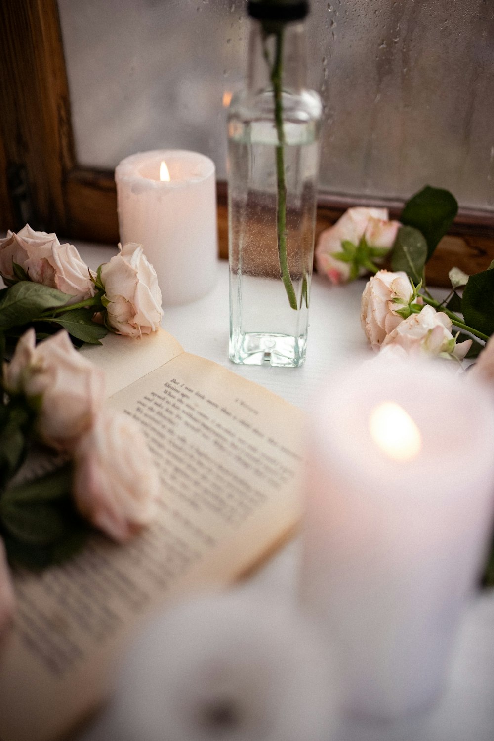 a table topped with a book and a vase filled with flowers