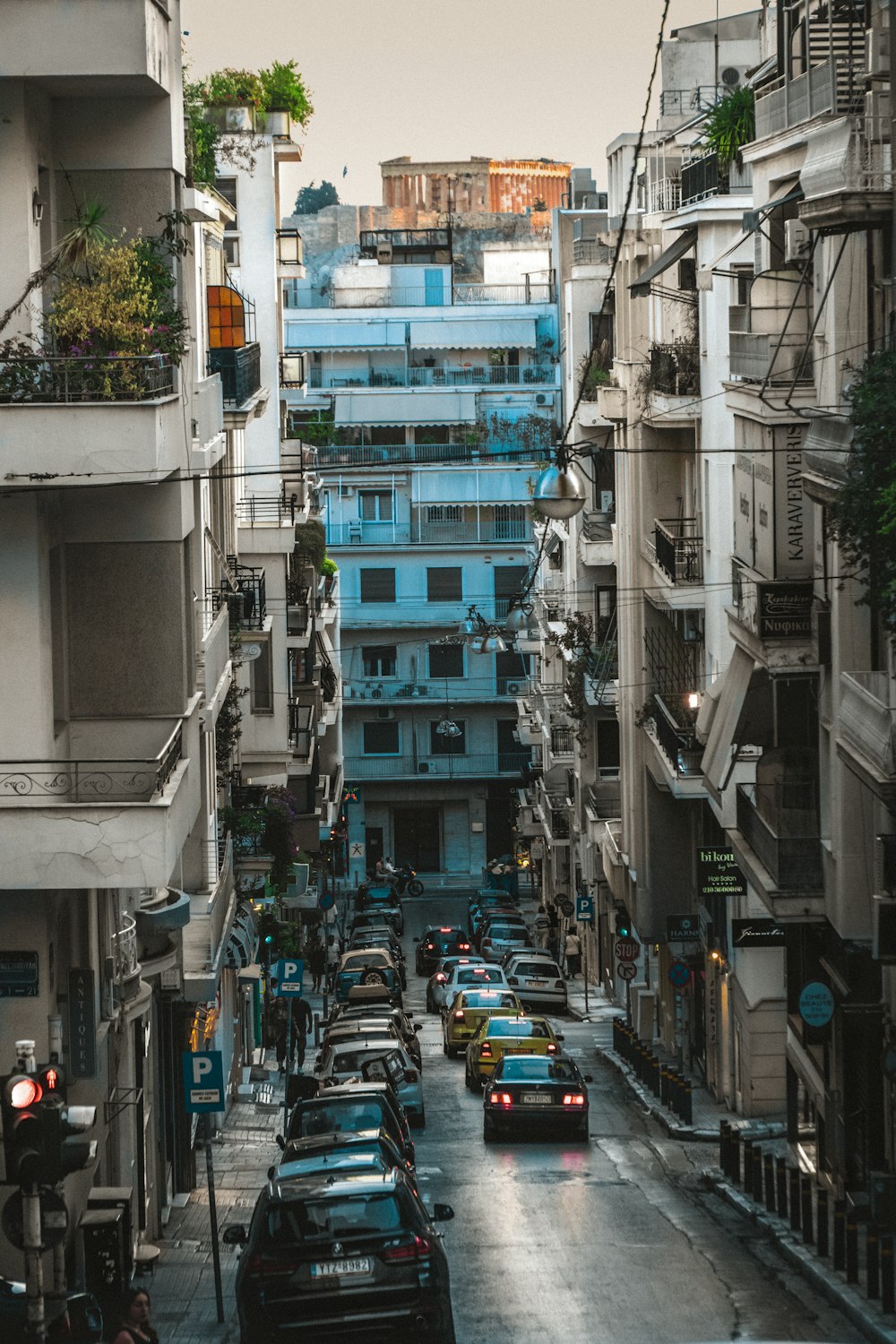 a city street filled with lots of traffic next to tall buildings