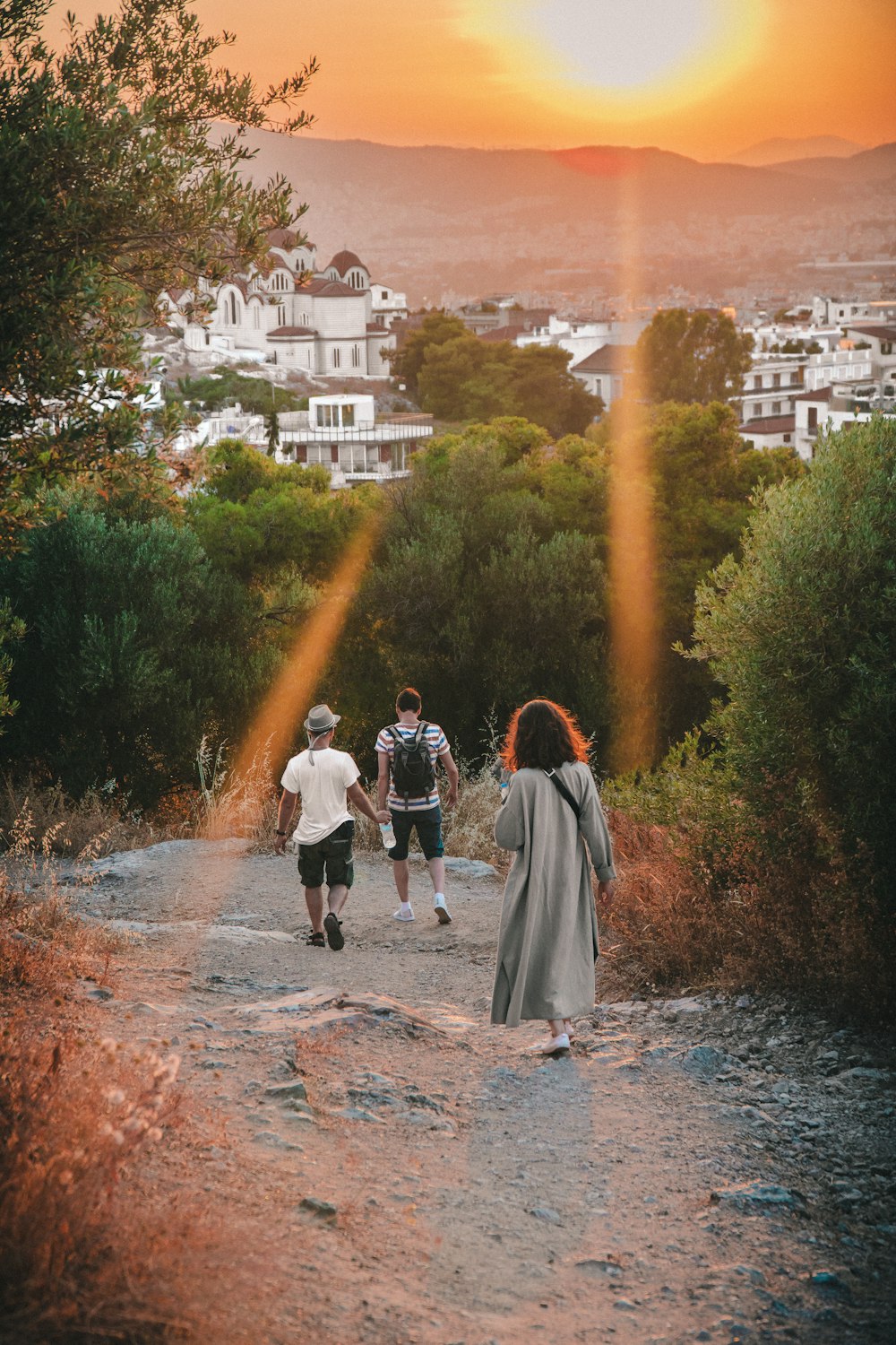 a group of people walking down a dirt road