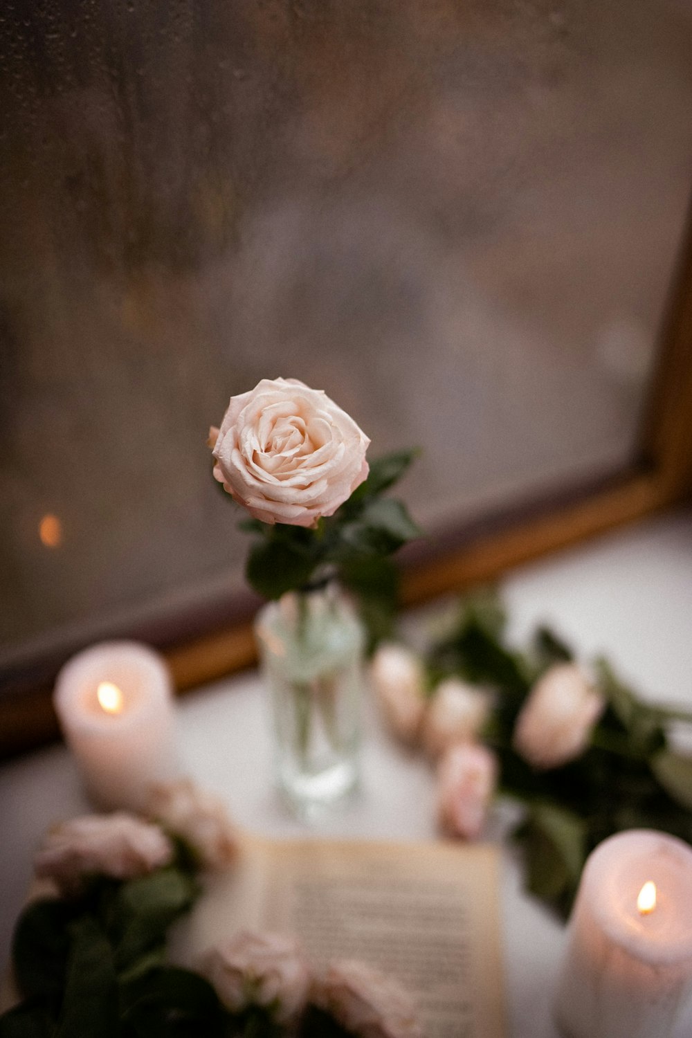 a vase of flowers and candles on a table