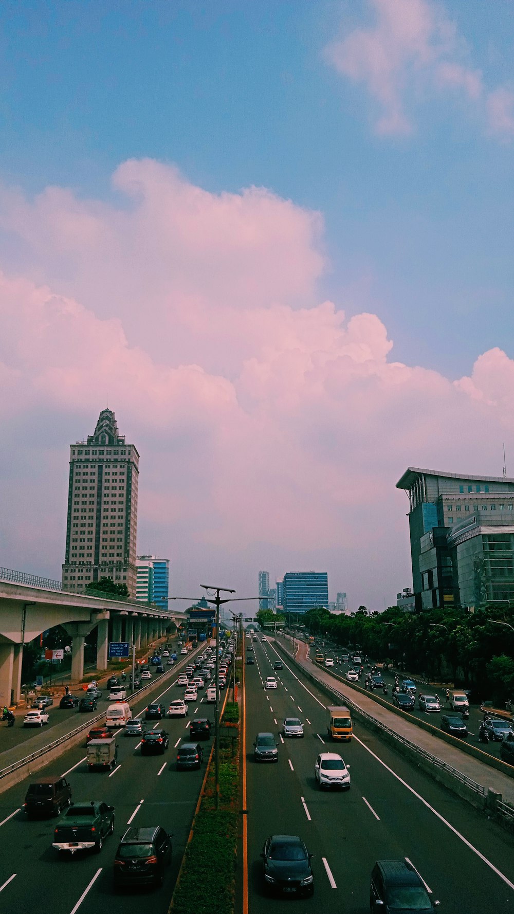 a view of a highway with cars and buildings in the background