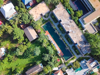 Swimming pool area surrounded by green plants in a residential complex