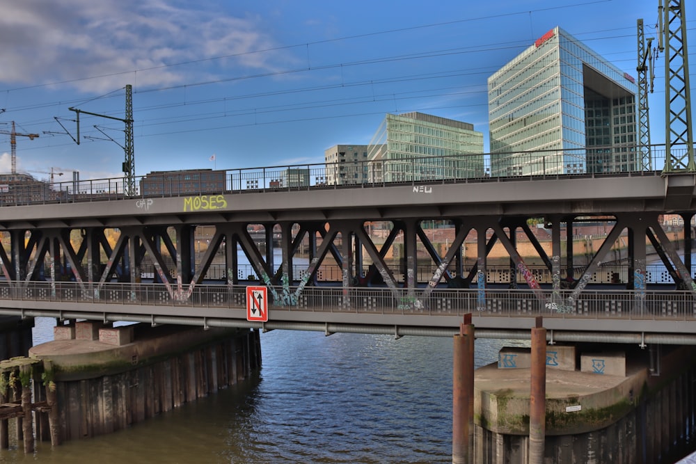 a bridge over a body of water with buildings in the background
