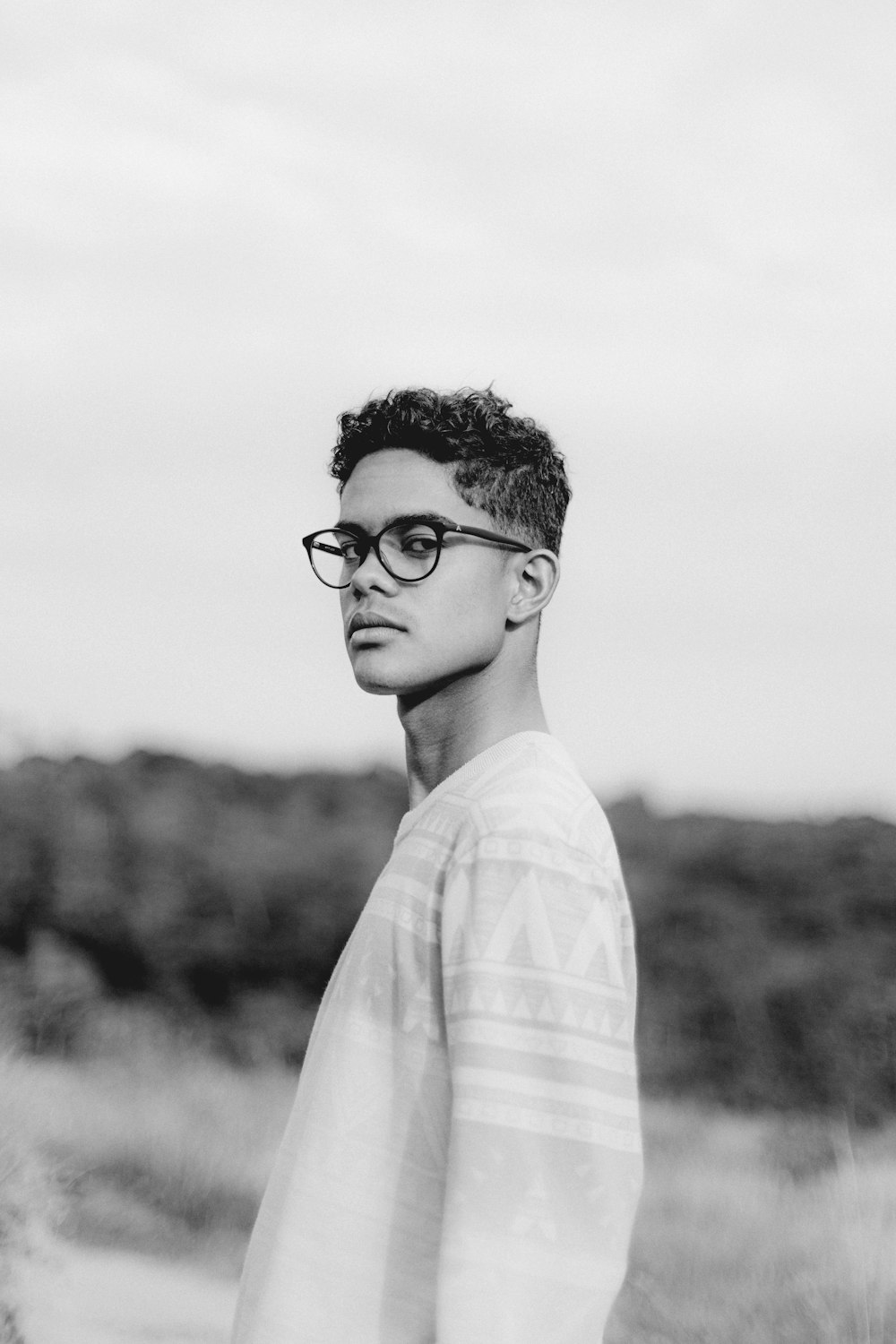 a black and white photo of a man wearing glasses