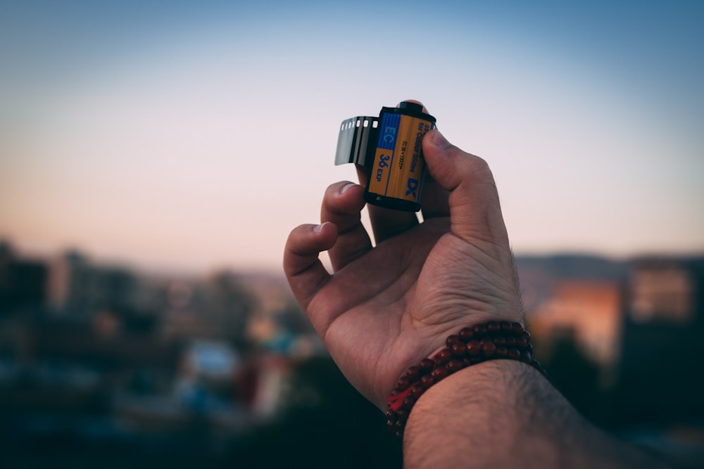 a person holding a small camera in their hand