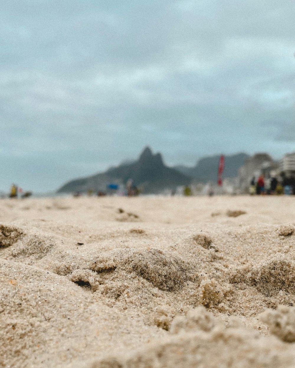 a close up of sand on a beach with people in the background