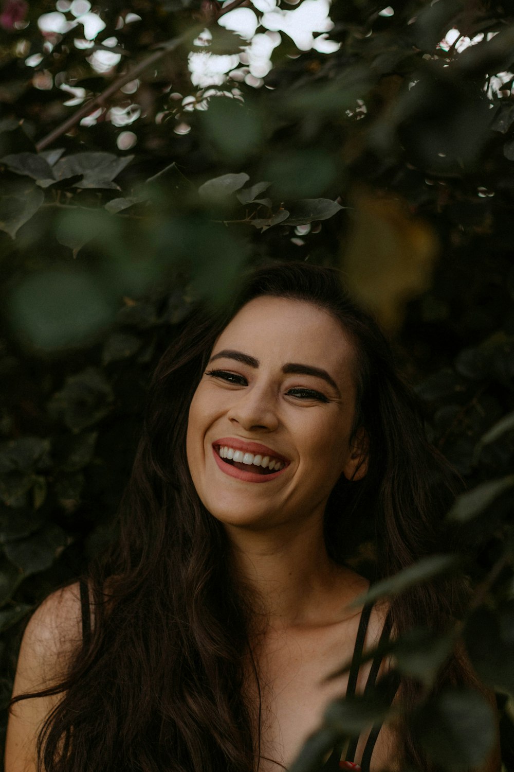 uma mulher com longos cabelos escuros sorrindo para a câmera