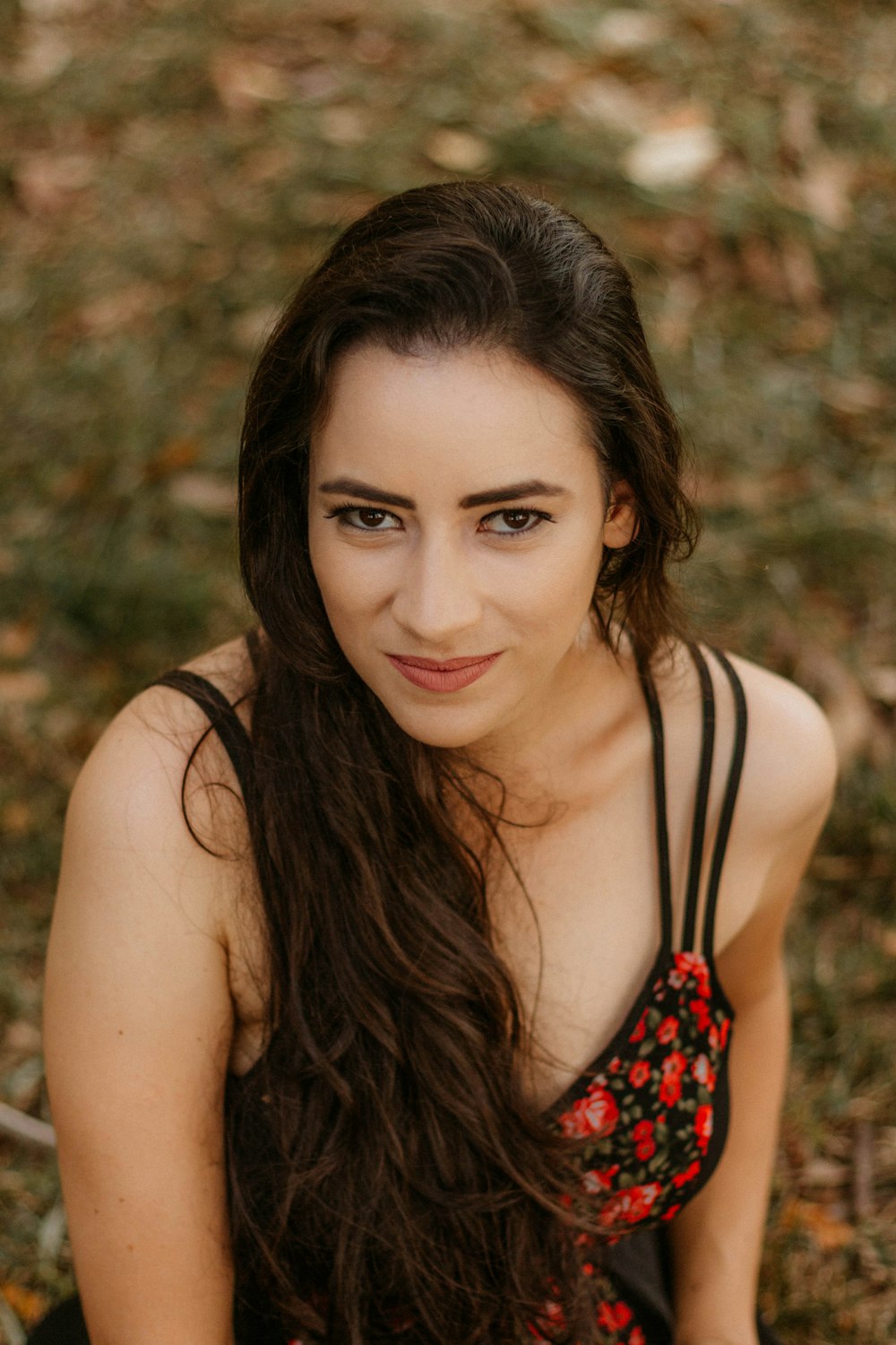 a woman with long hair sitting on the ground