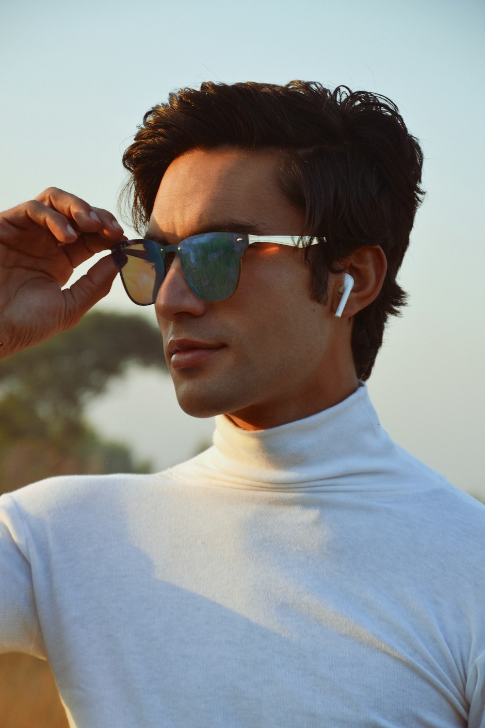 a man wearing sunglasses and a white shirt