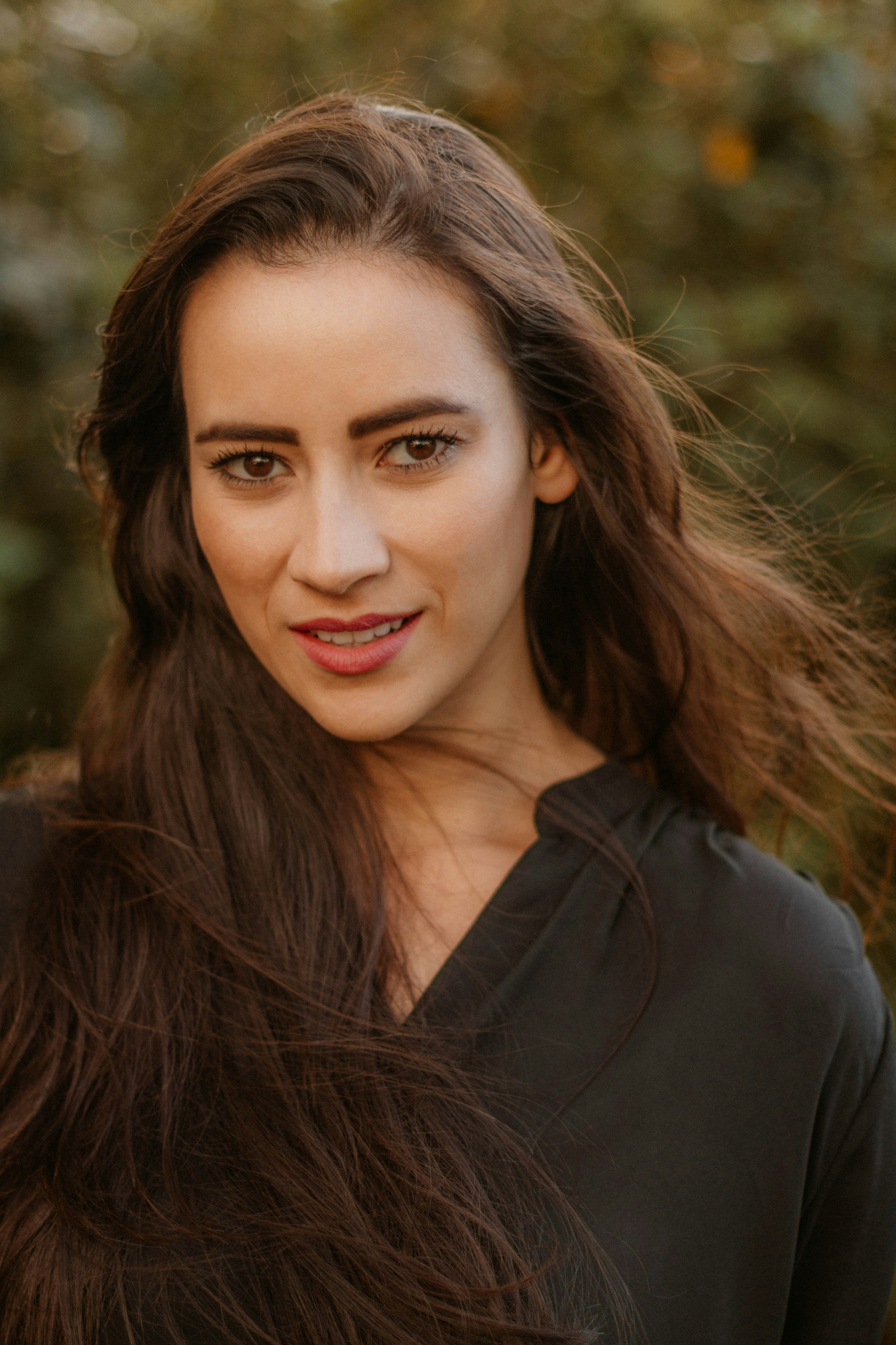 a woman with long brown hair and a black shirt