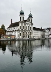 a large white building sitting next to a body of water