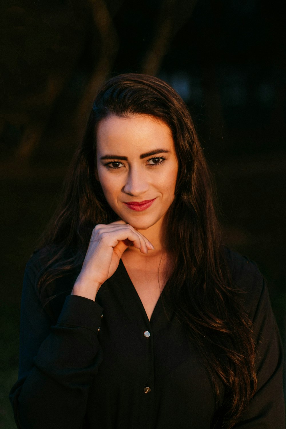 a woman posing for a picture with her hand on her chin