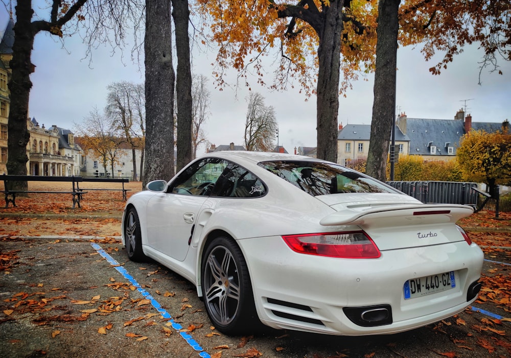 a white sports car parked in a parking lot