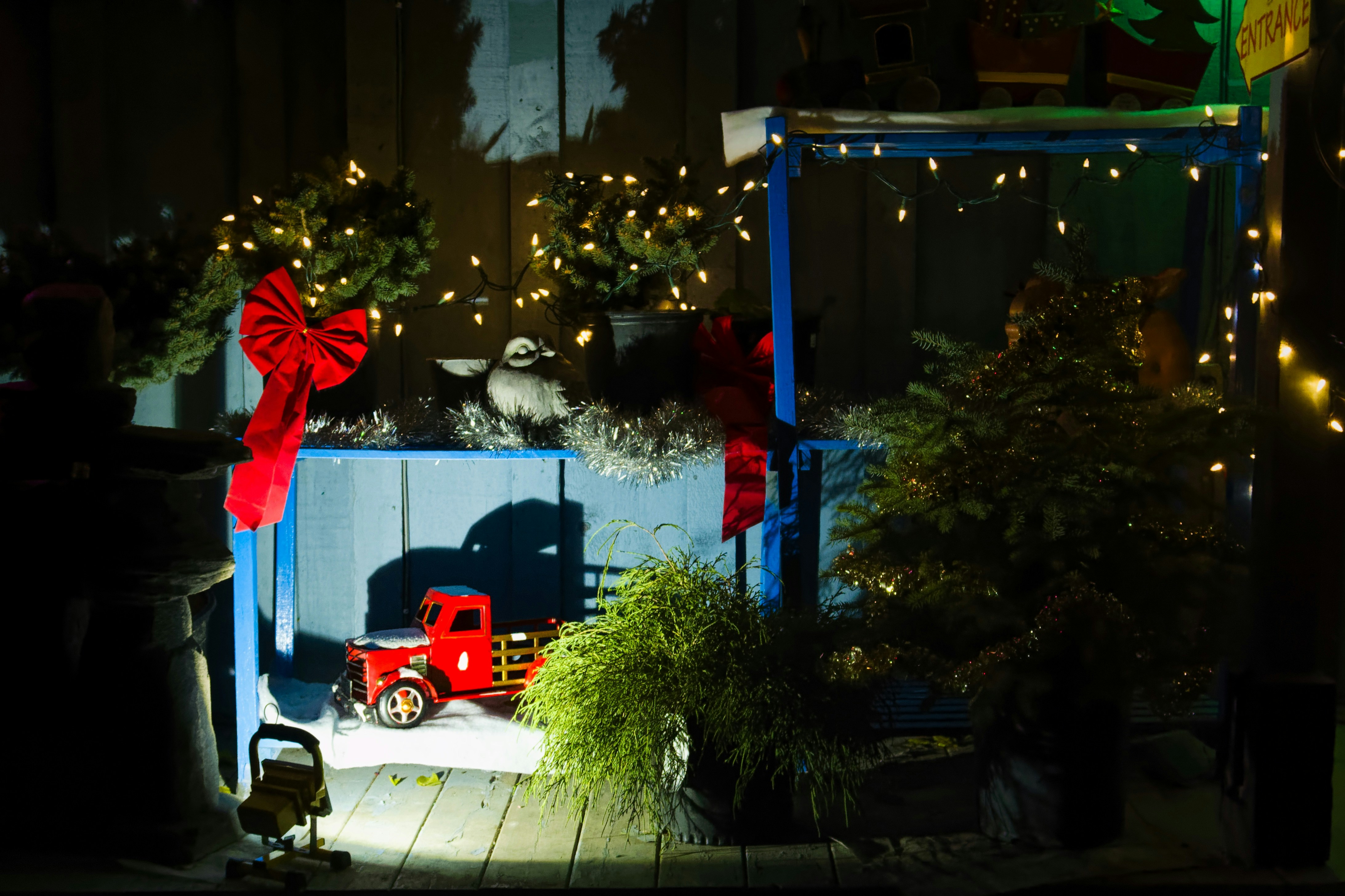 a red truck parked next to a christmas tree