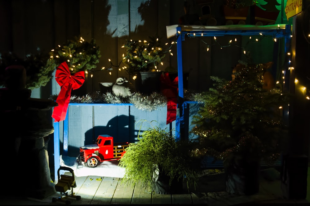 a red truck parked next to a christmas tree