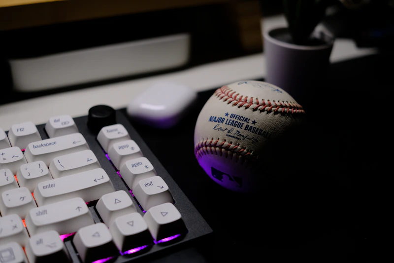 PC 키보드 위에 놓인 야구공, 데스크톱으로 KBO 중계를 보는 상황