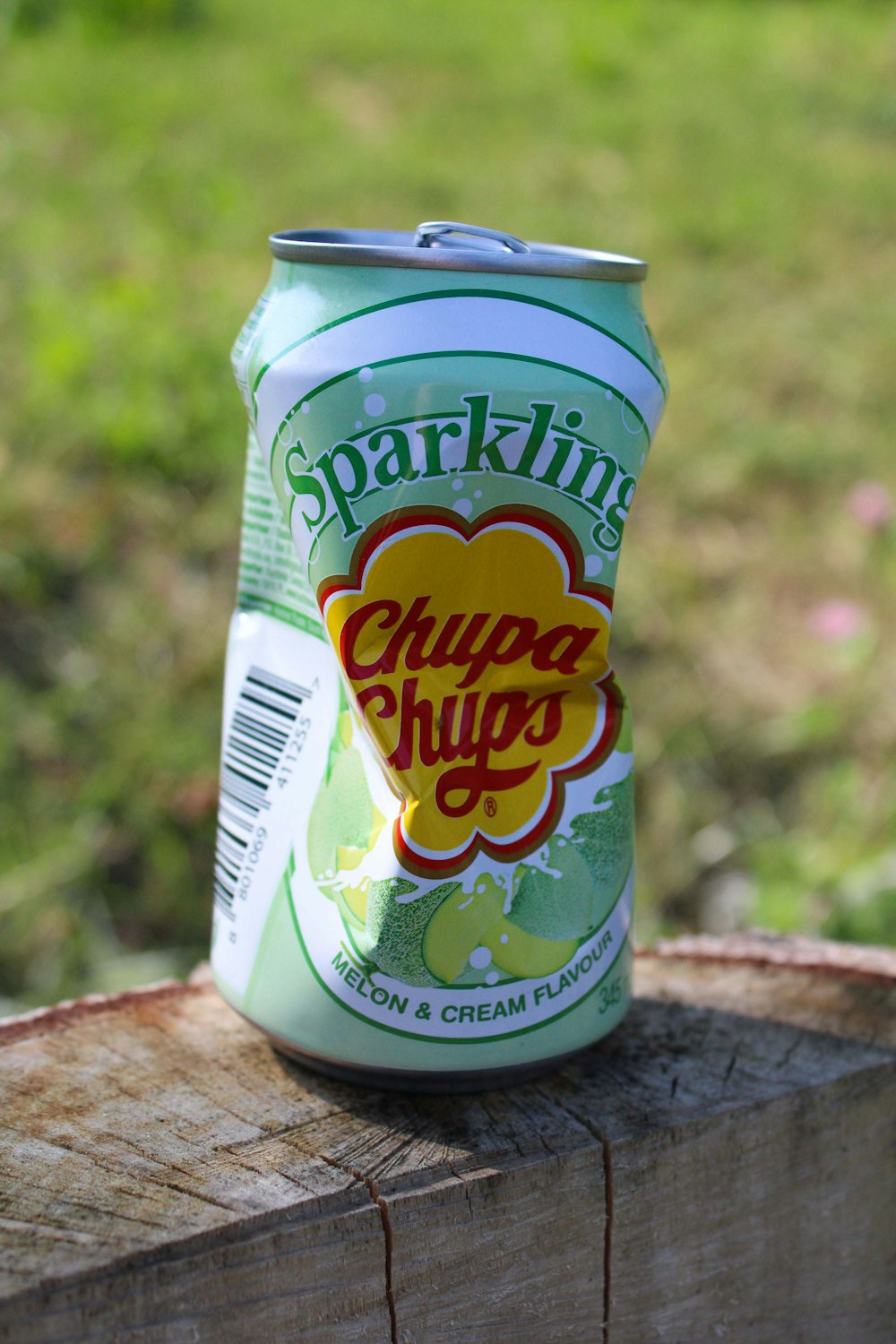 a can of sparkling guacamole sitting on top of a piece of wood