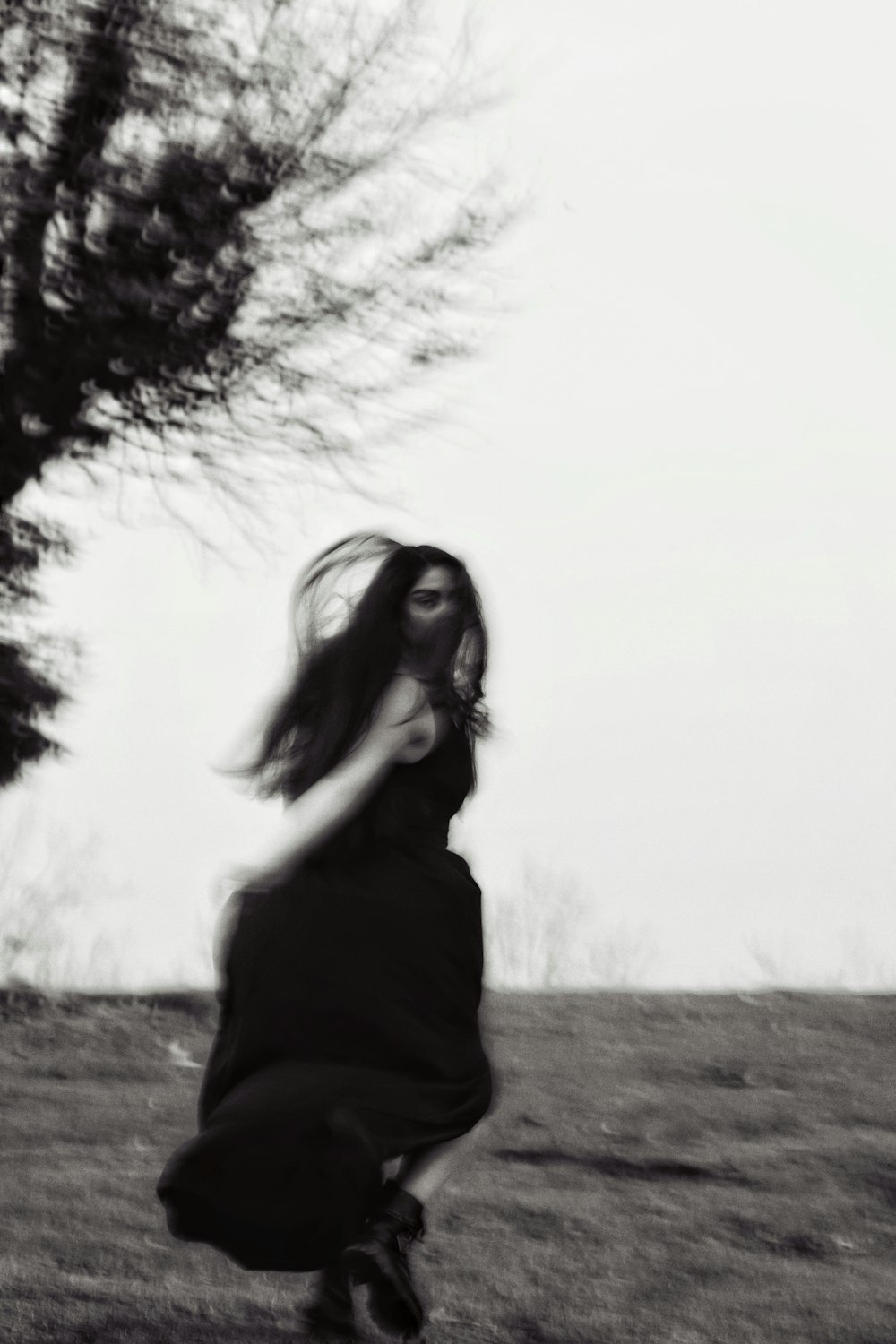 a woman in a black dress running through a field
