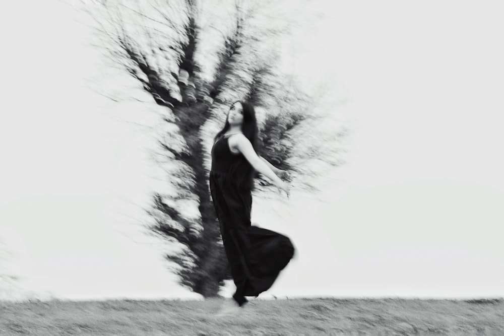 a black and white photo of a woman in a long dress