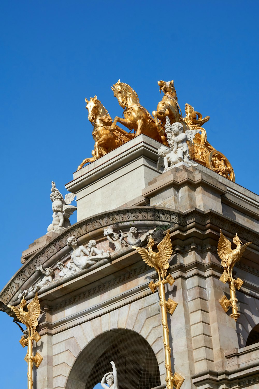 a clock tower with gold statues on top of it