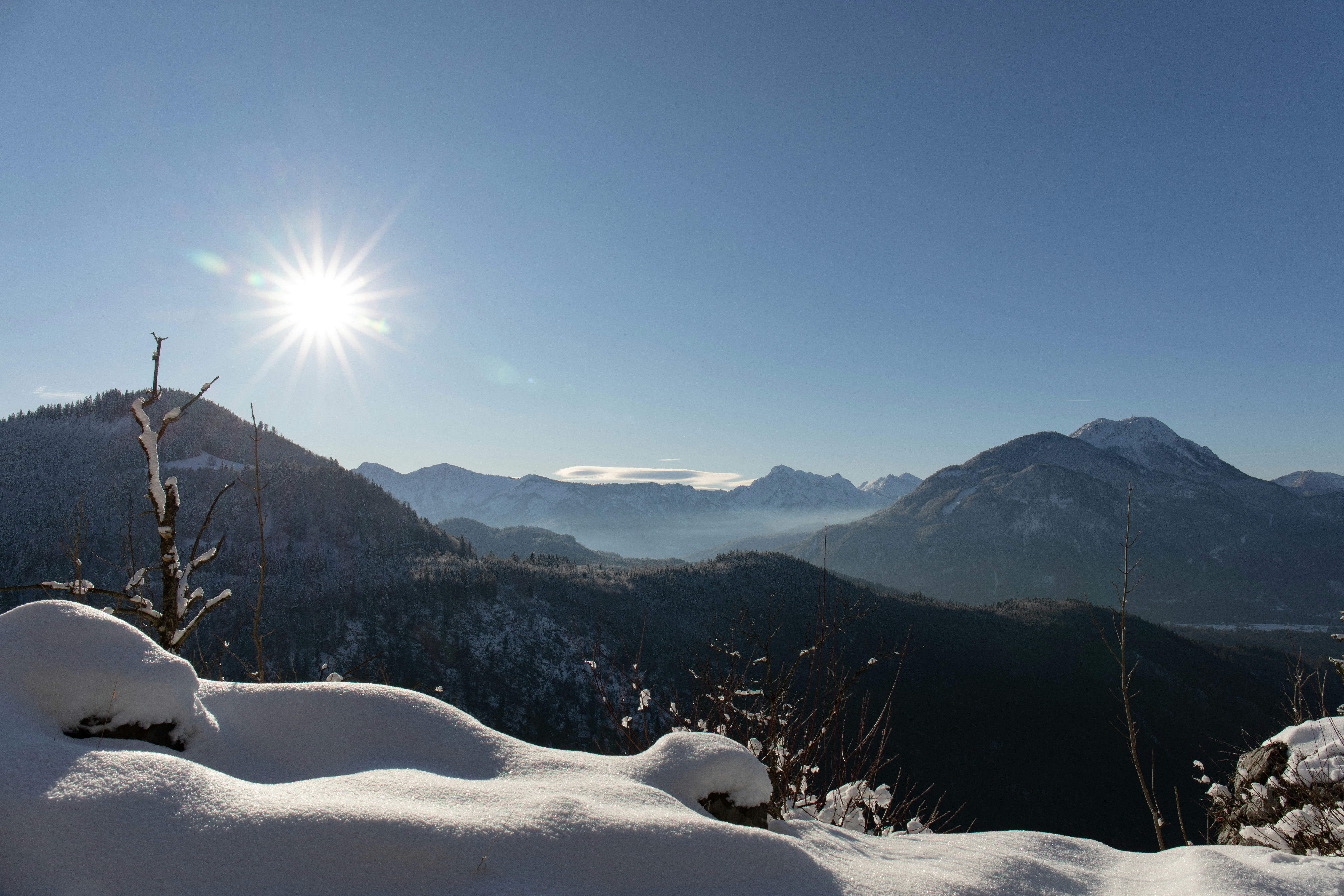 the sun shines brightly over a snowy mountain range, 