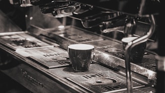 a coffee machine with two cups on top of it