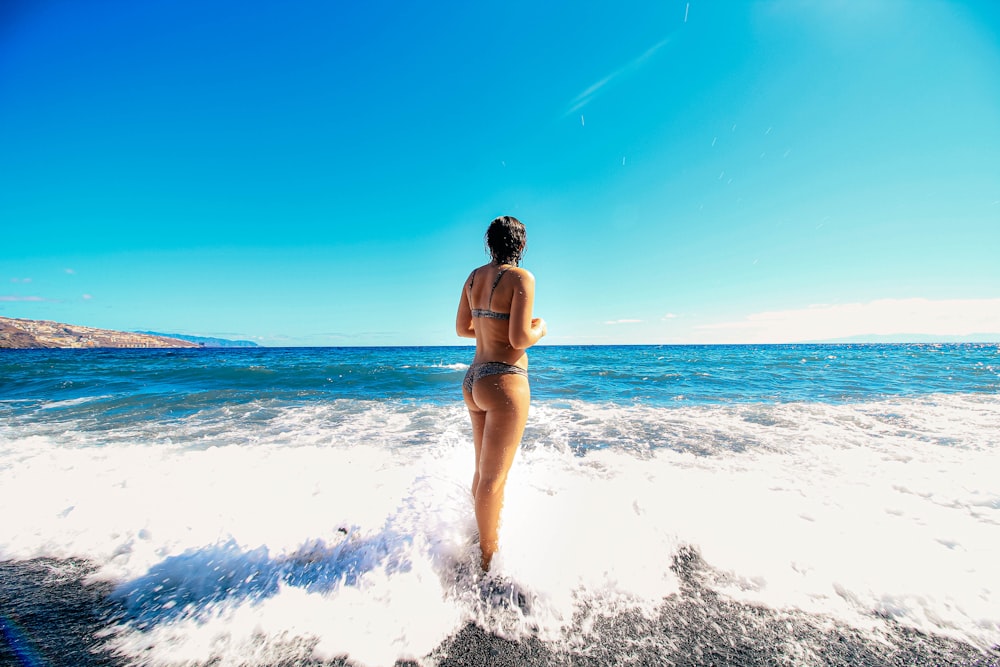 a woman in a bikini standing in the water