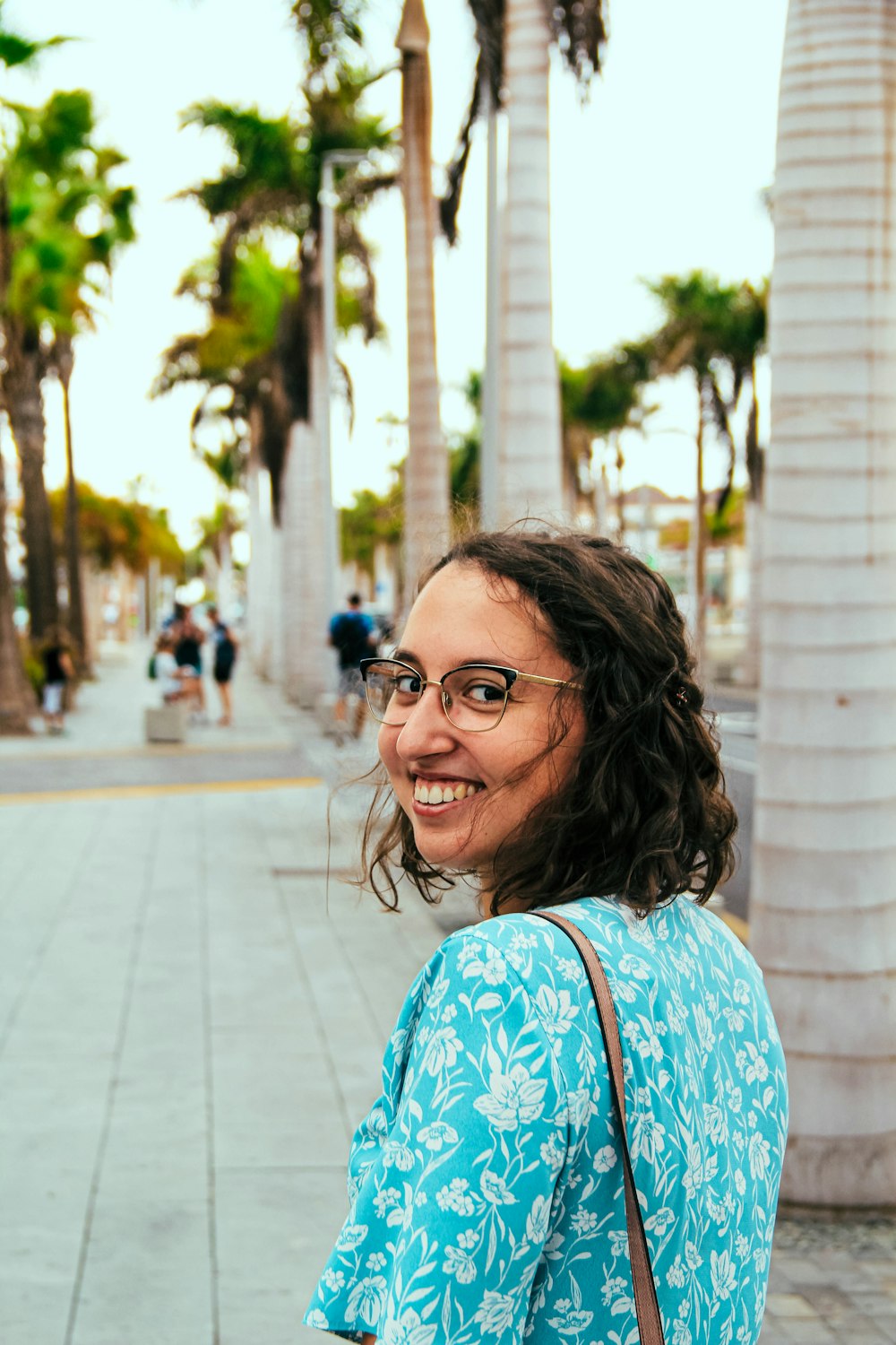 a woman in a blue top is smiling for the camera