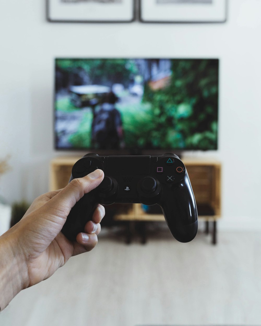 a person holding a video game controller in front of a tv