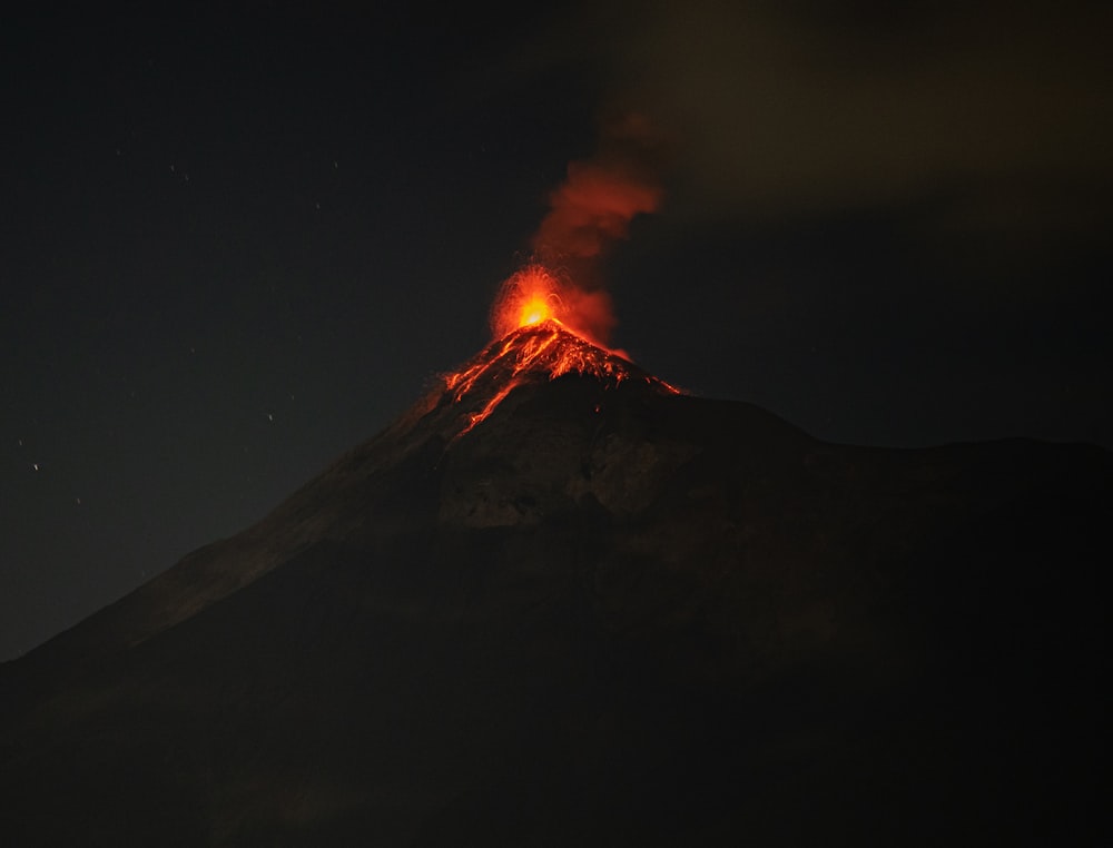 a volcano erupts lava as it erupts into the night sky