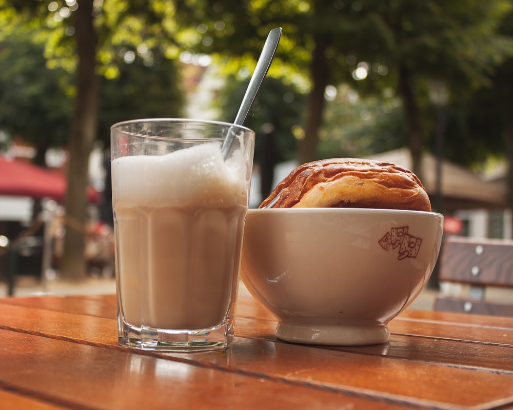 eine Schüssel mit Essen und ein Glas Milch auf einem Tisch