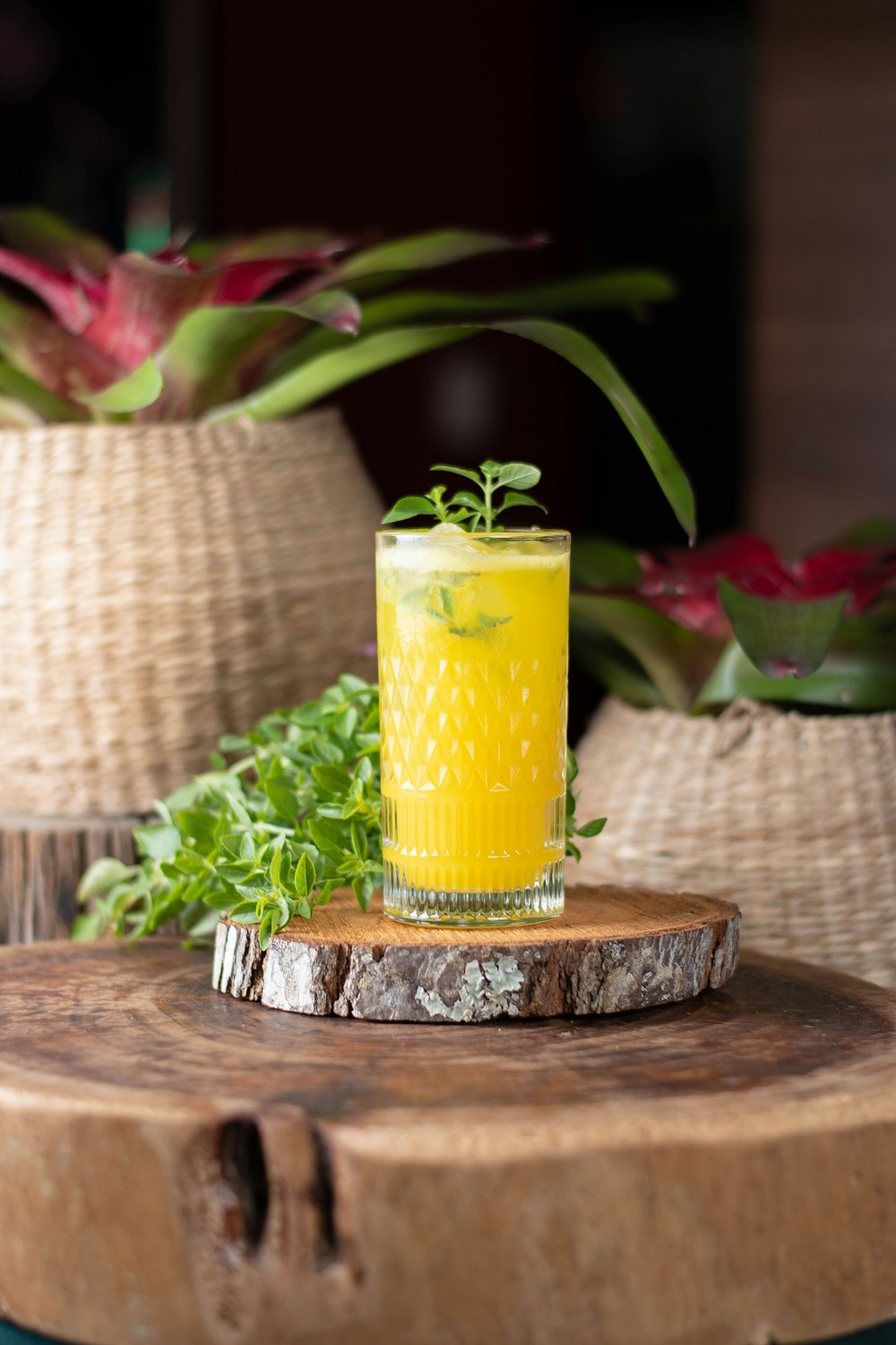 a glass of orange juice sitting on top of a wooden table