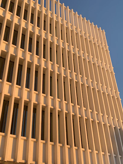 Elegant modern building facade with deep blue and gold accents under soft natural light.