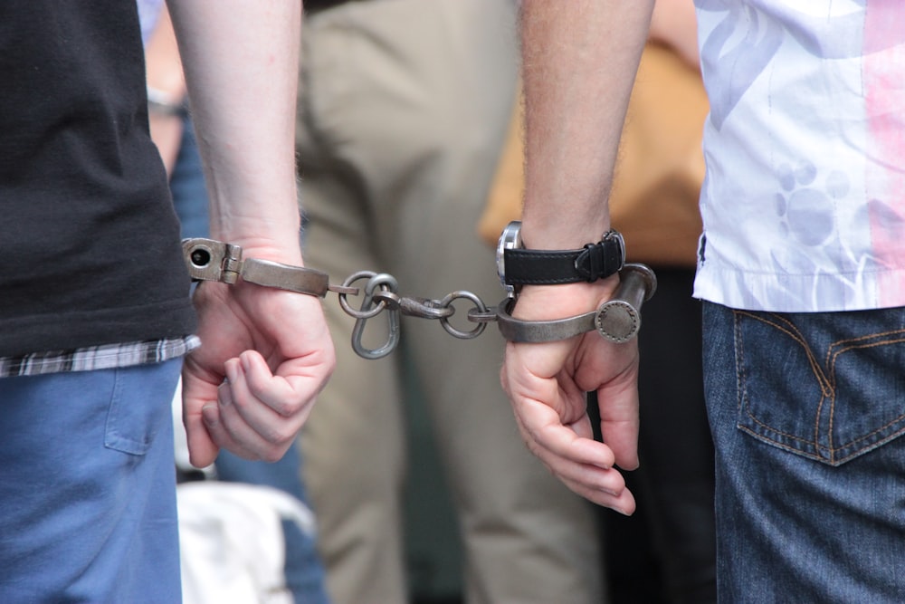 two people holding hands with handcuffs on them