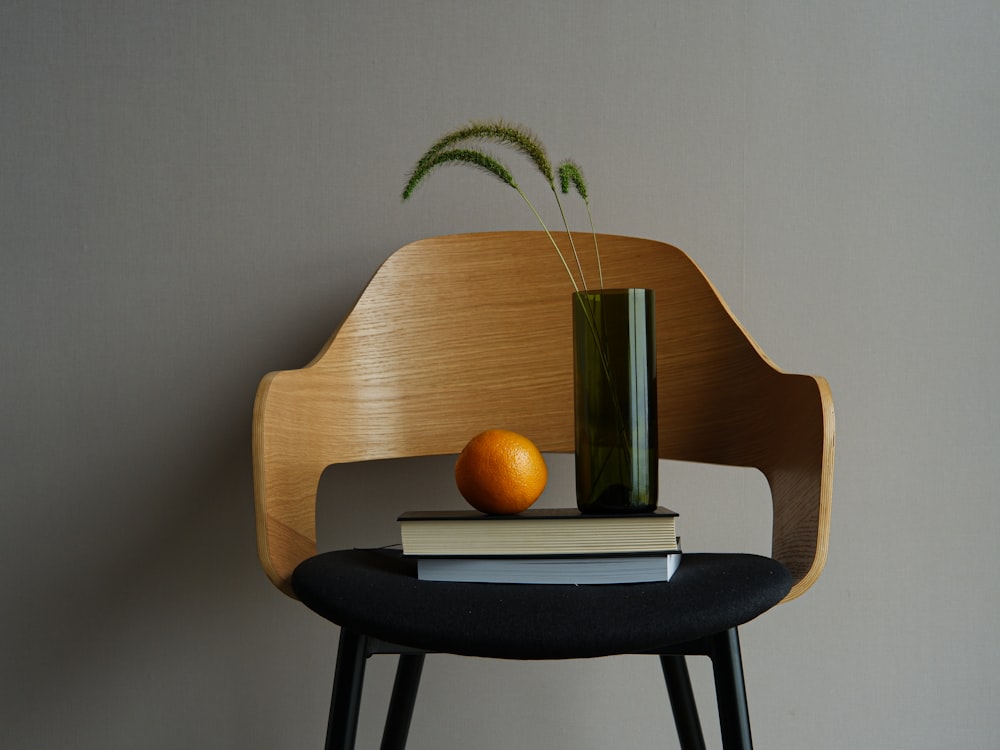 una silla de madera con un libro y un jarrón encima