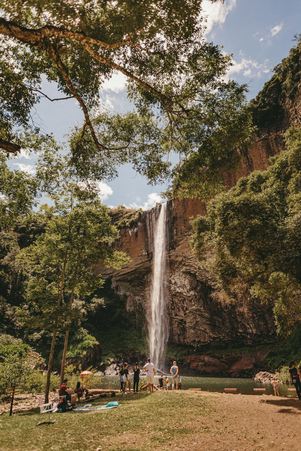 a group of people standing in front of a waterfall