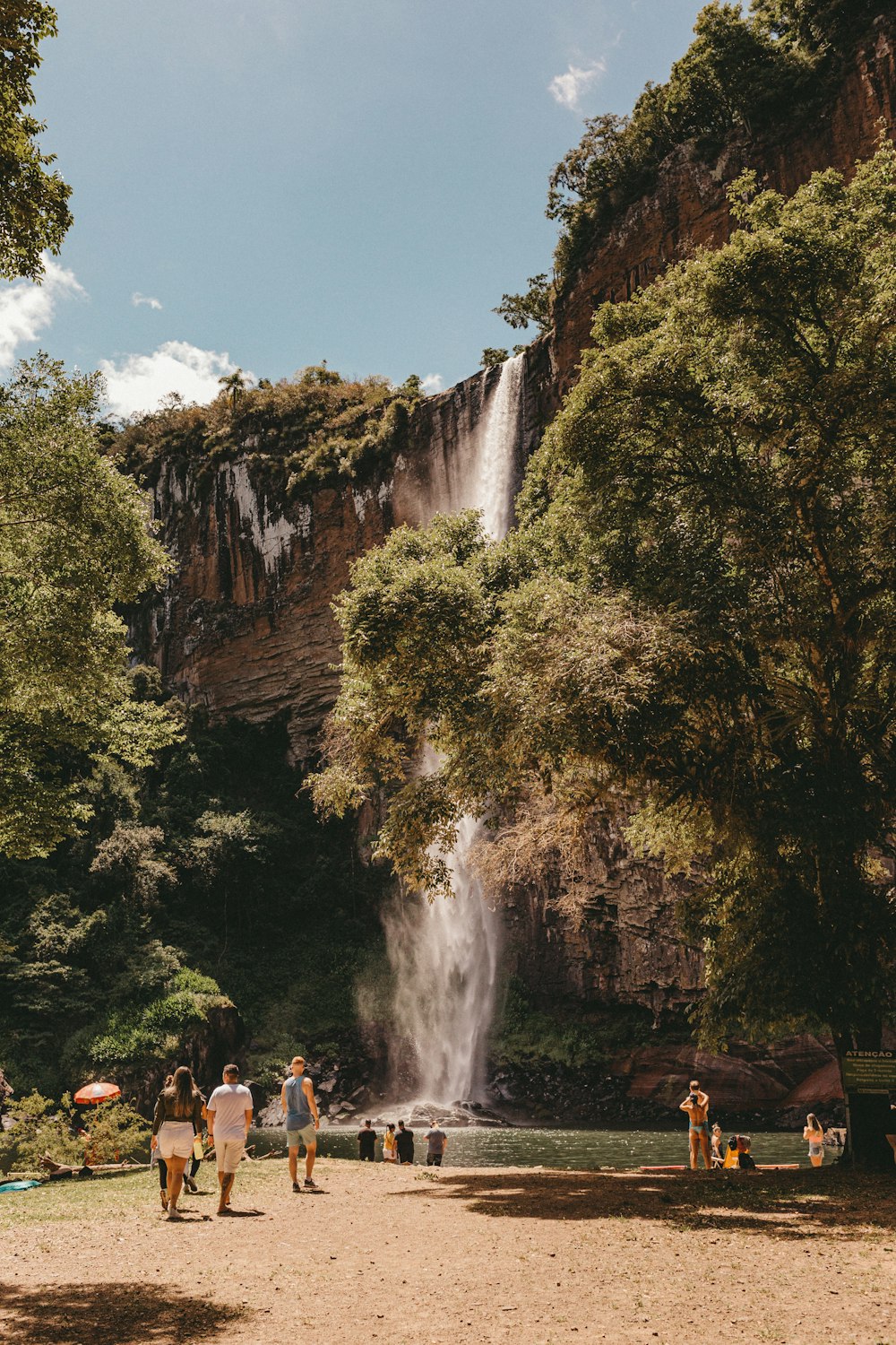 Un grupo de personas de pie frente a una cascada