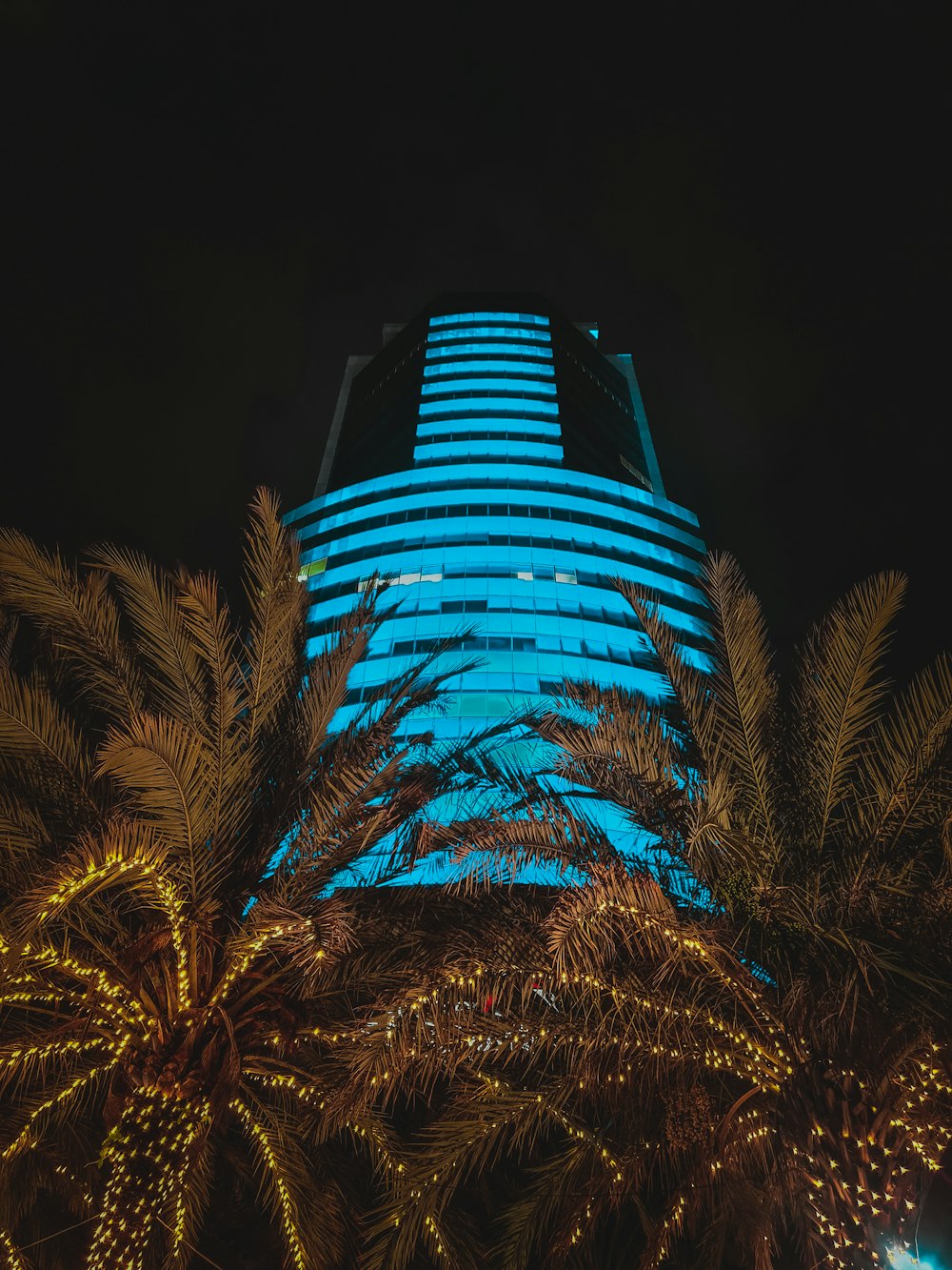 Un edificio alto iluminado con luces azules