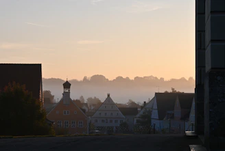 A serene sunrise over a secluded European village nestled by a calm river.