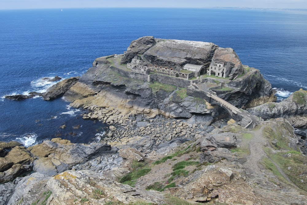 an old building on top of a rocky cliff by the ocean