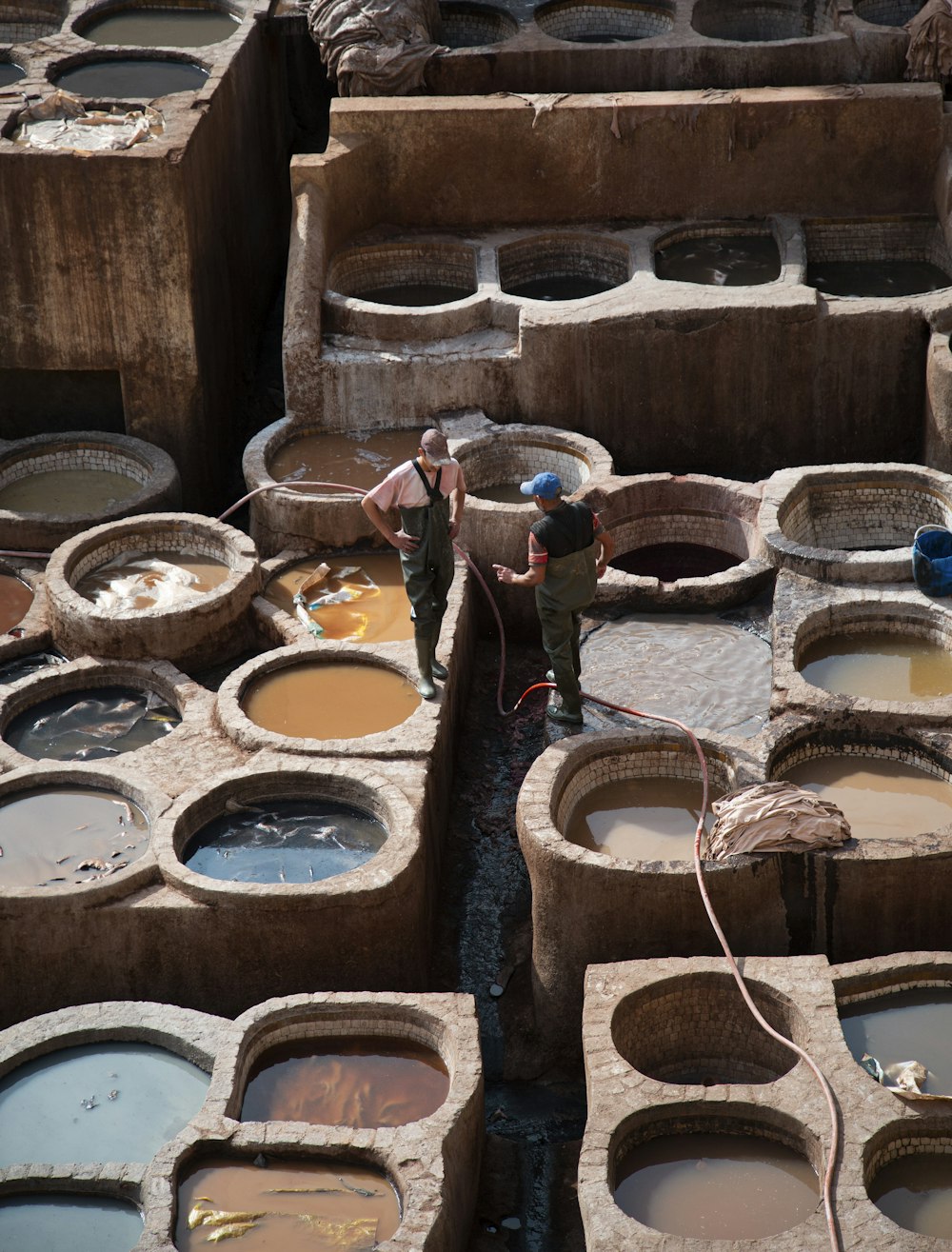 two men are standing in front of a large number of clay pots