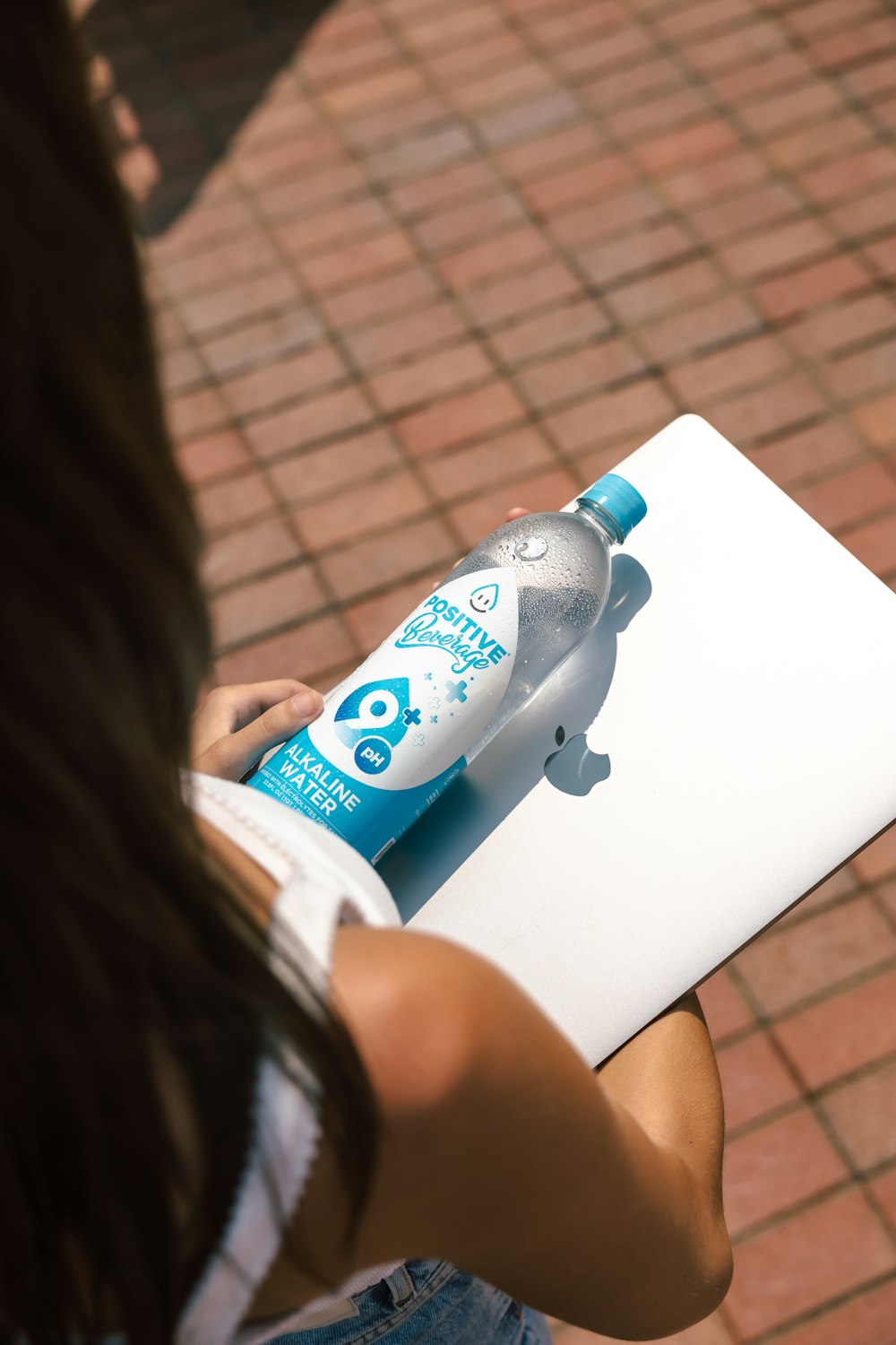 a woman holding a bottle of water on top of a table