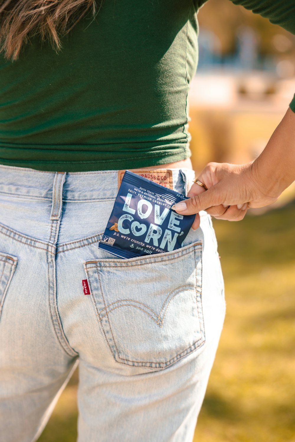 a woman holding a box of love corn in her pocket