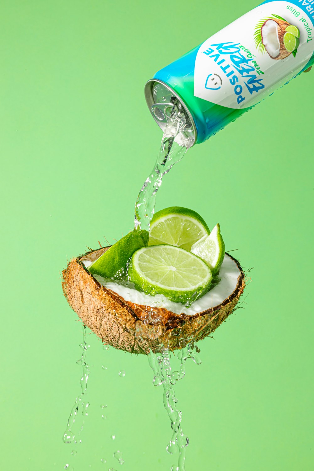 a can of coconut water being poured into a coconut