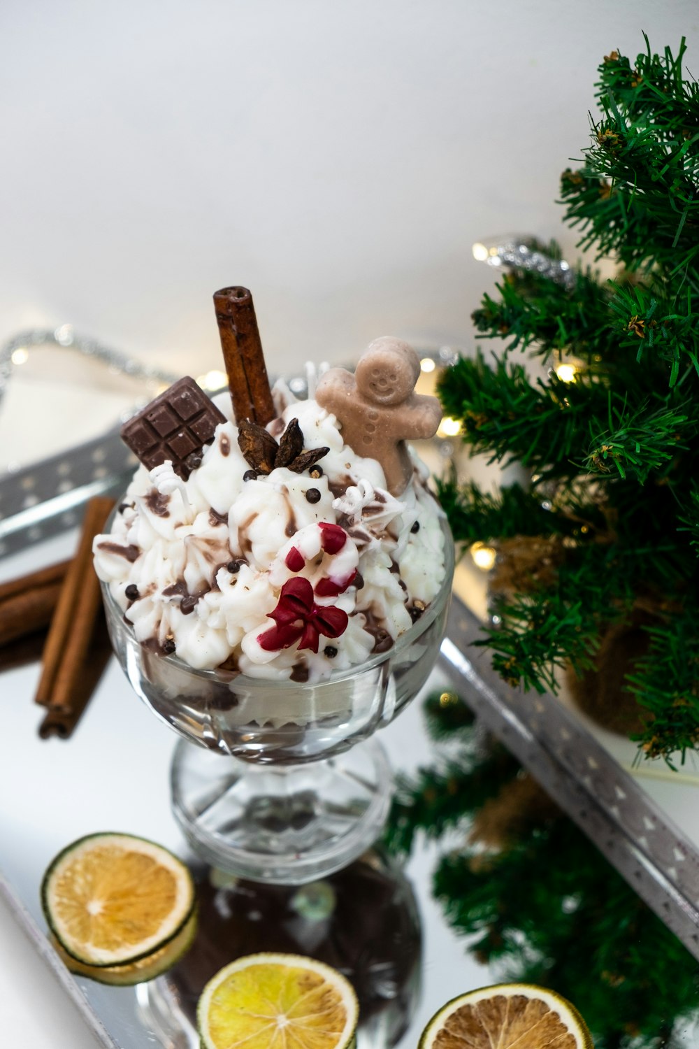 a glass bowl filled with a dessert next to a christmas tree