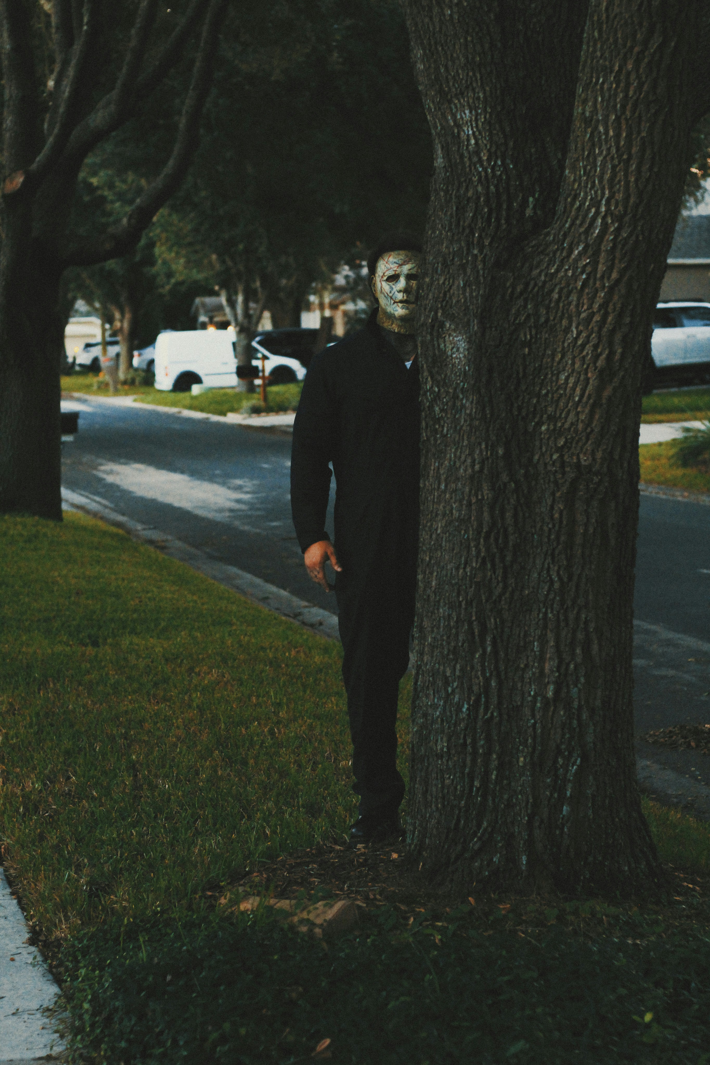 Foto Un hombre parado junto a un árbol en una acera – Imagen Vestir ...