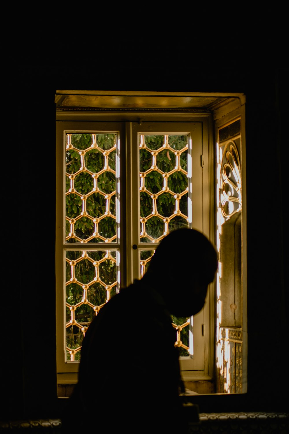 a man standing in front of a window in a dark room