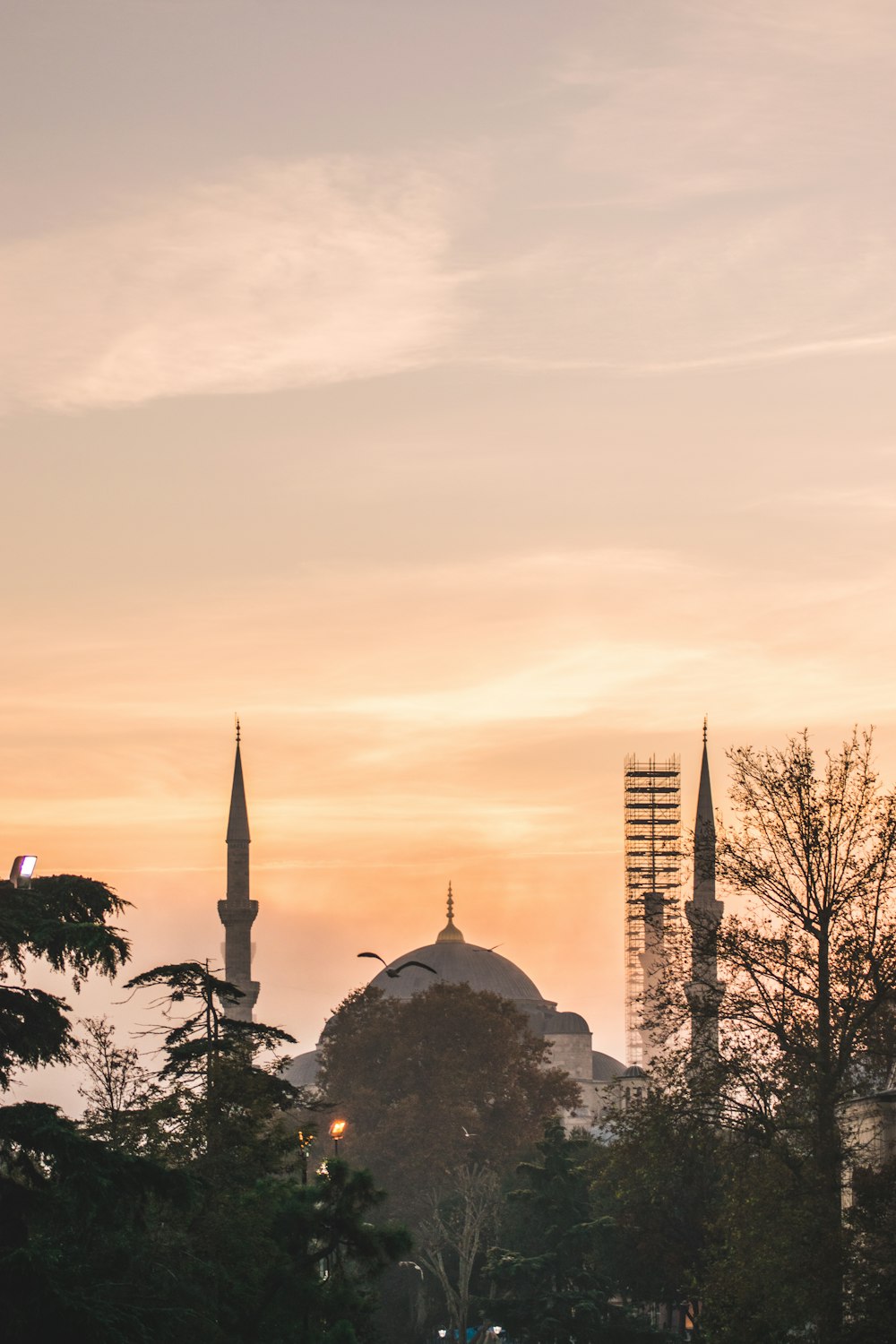 a sunset view of a city with a mosque in the background
