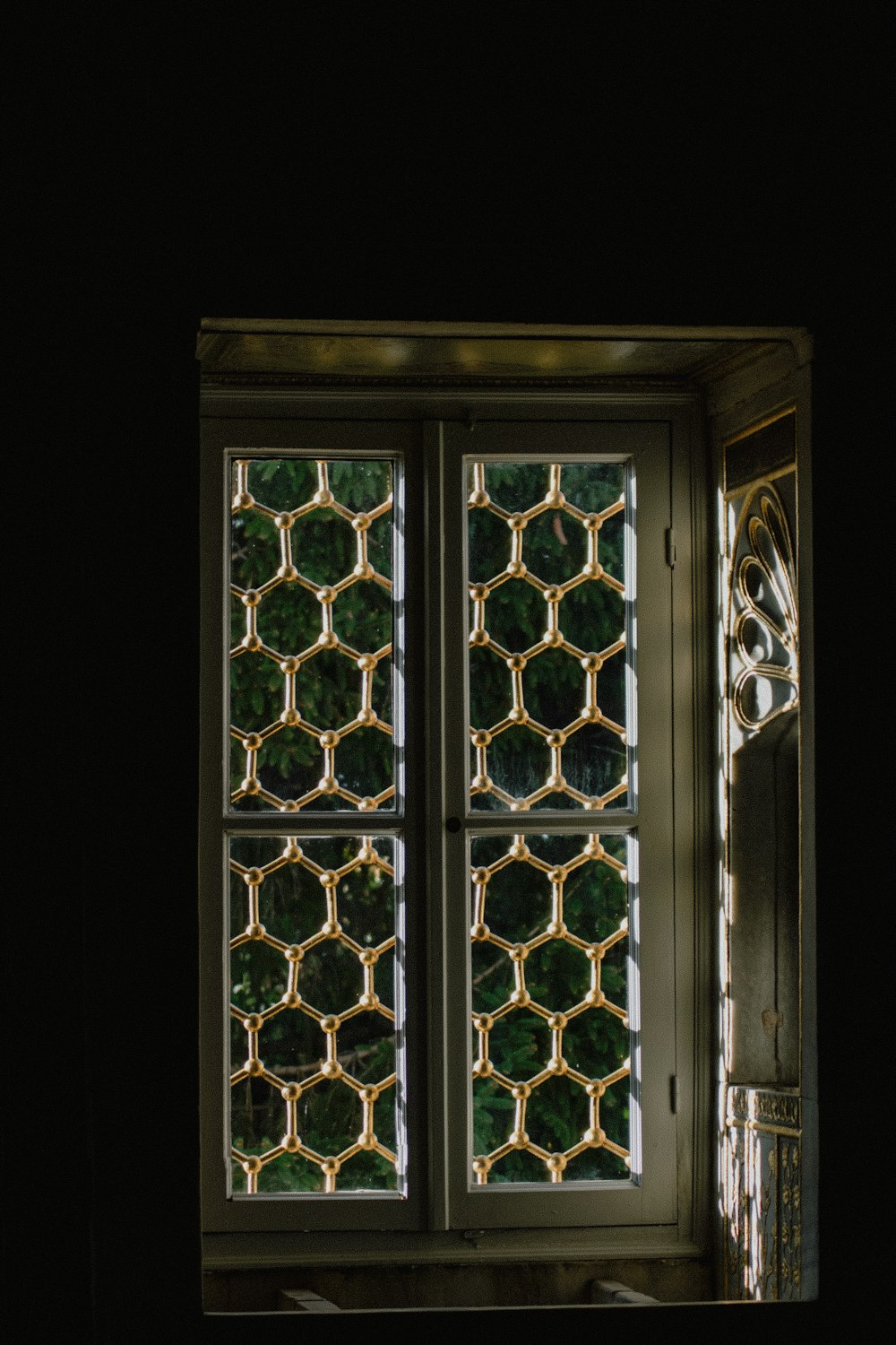 a window in a dark room with a light coming through it