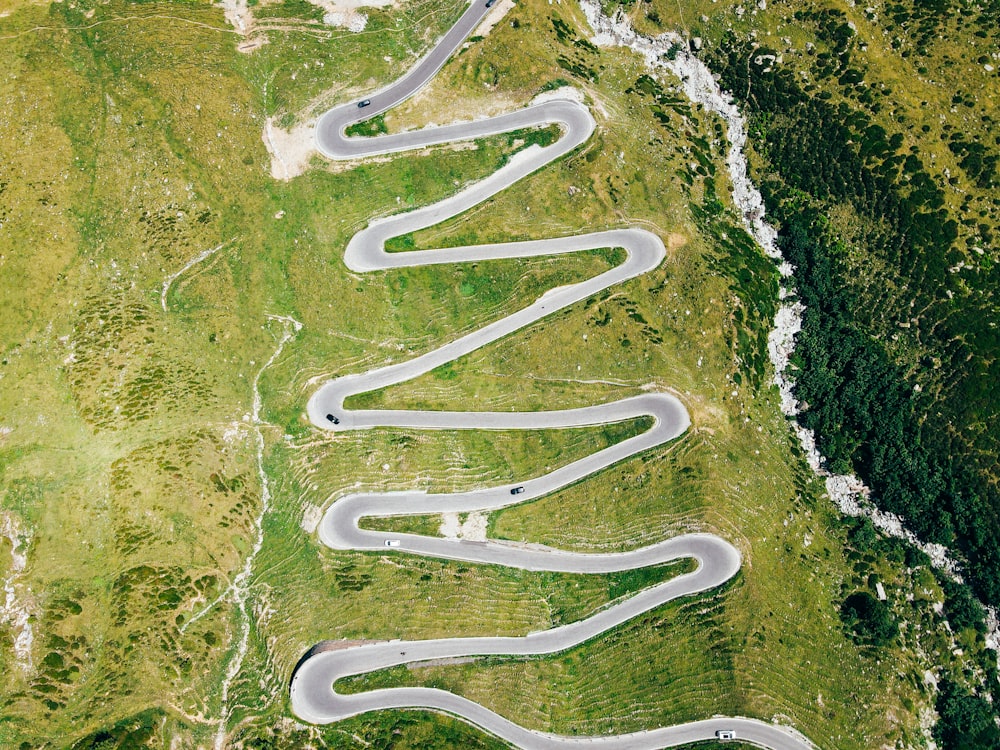 an aerial view of a winding road in the mountains